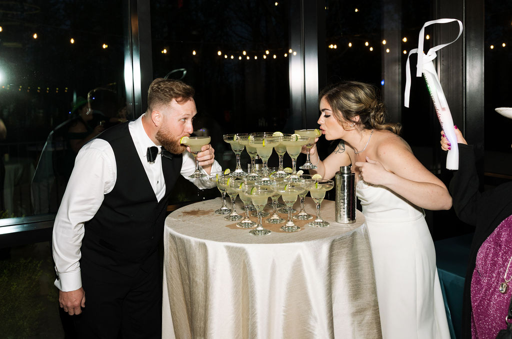 Bride and groom back to back in modern hallway space with chandeliers during a nichols heir wedding