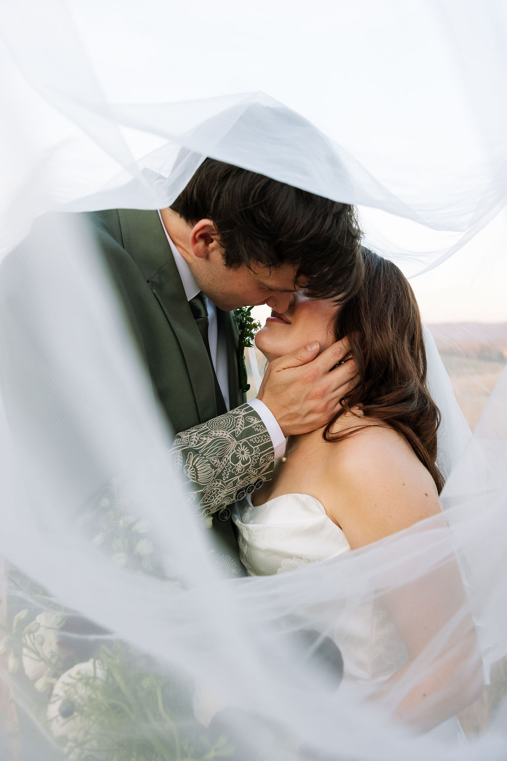 Couple sharing a close, intimate moment beneath the bride’s veil