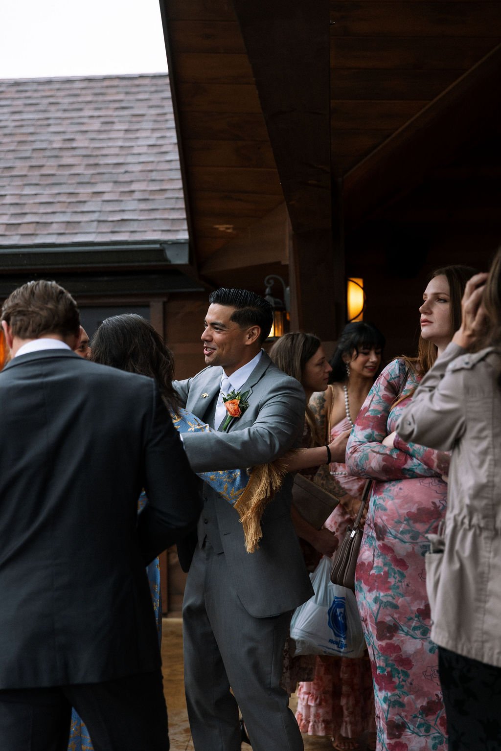 Groom greeting guests during cocktail hour outside the reception space
