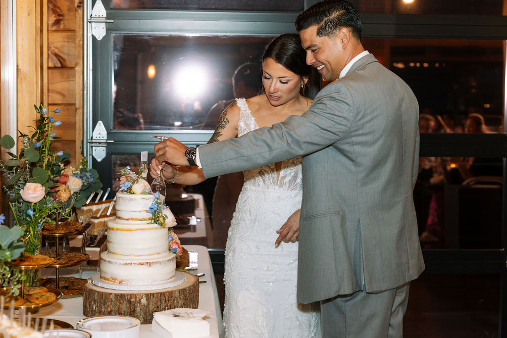 Couple cutting their wedding cake together during reception inside The Magnolia Wedding Venue
