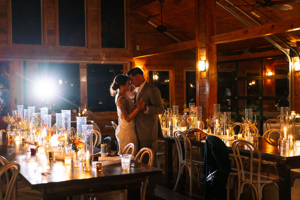 Bride and groom sharing a quiet first dance surrounded by candlelight inside The Magnolia Wedding Venue
