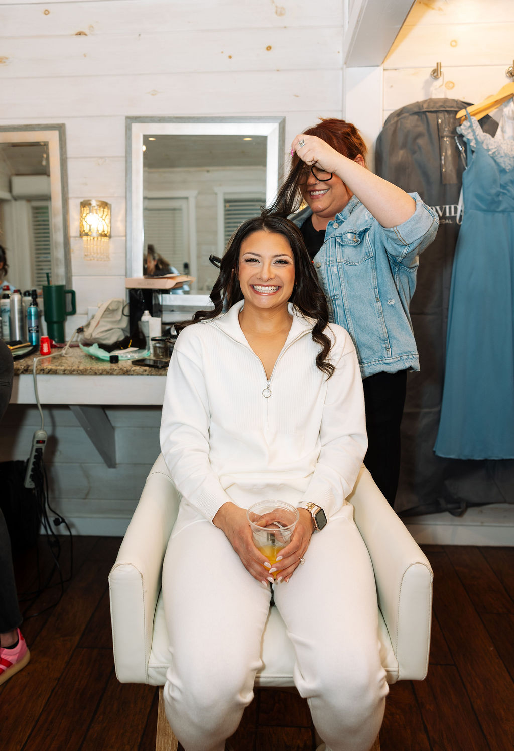 Bride smiling during hair and makeup in a getting-ready suite at The Magnolia Wedding Venue
