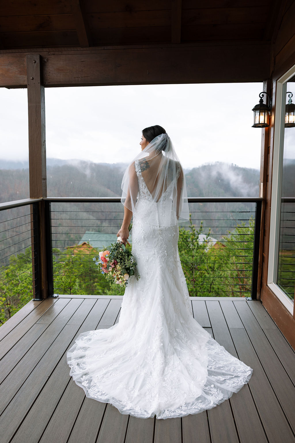 Bride standing on a covered balcony overlooking the Smoky Mountains at The Magnolia Wedding Venue

