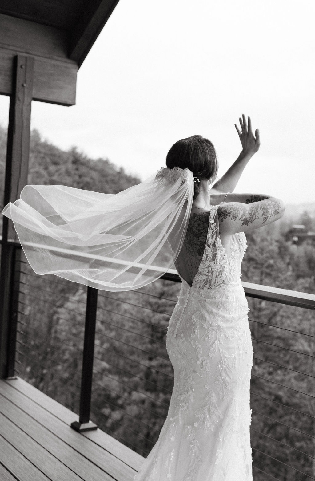 Black and white portrait of bride with veil moving in the wind on a mountain overlook