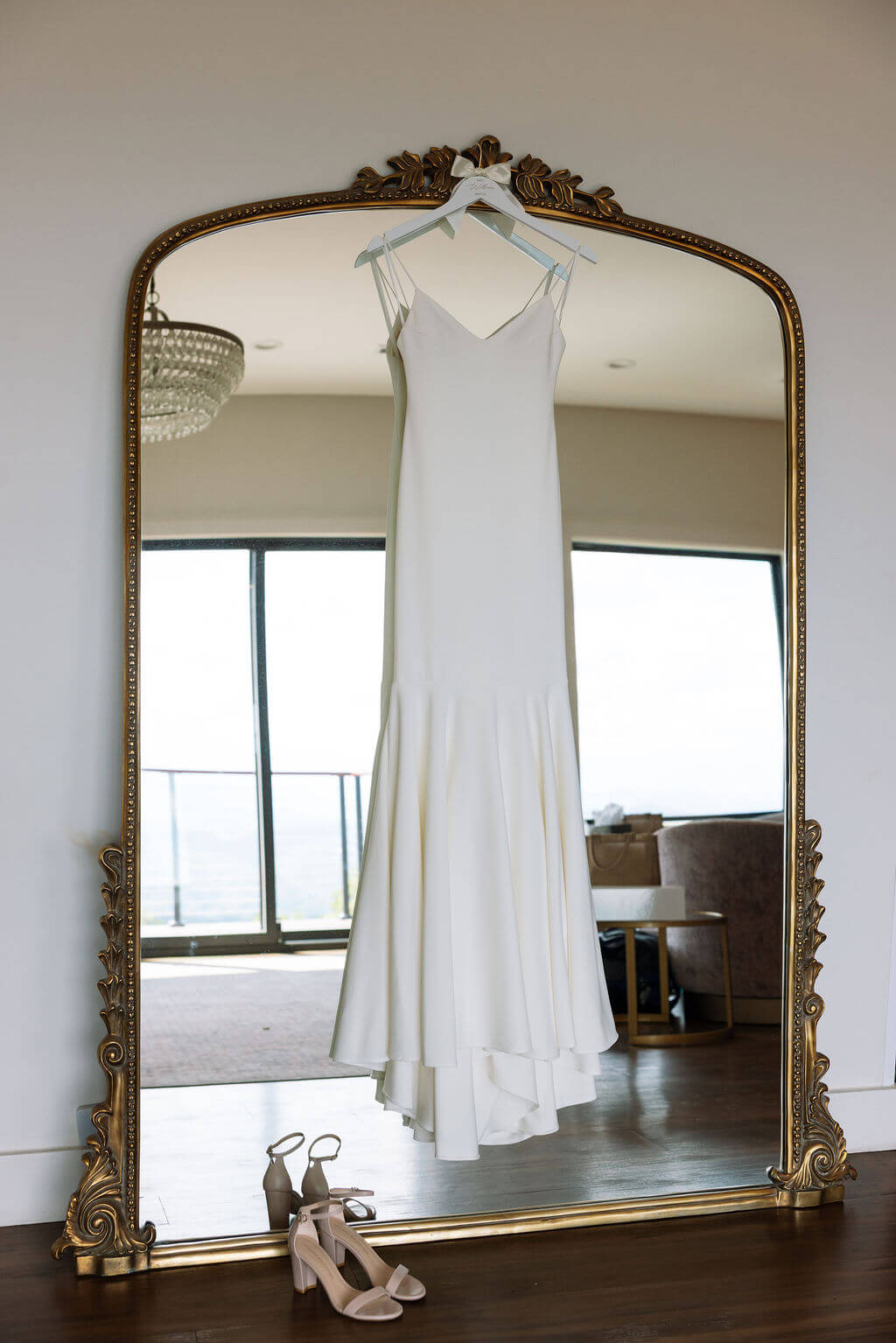 Minimalist wedding dress hanging in vintage mirror at a Knoxville wedding venue