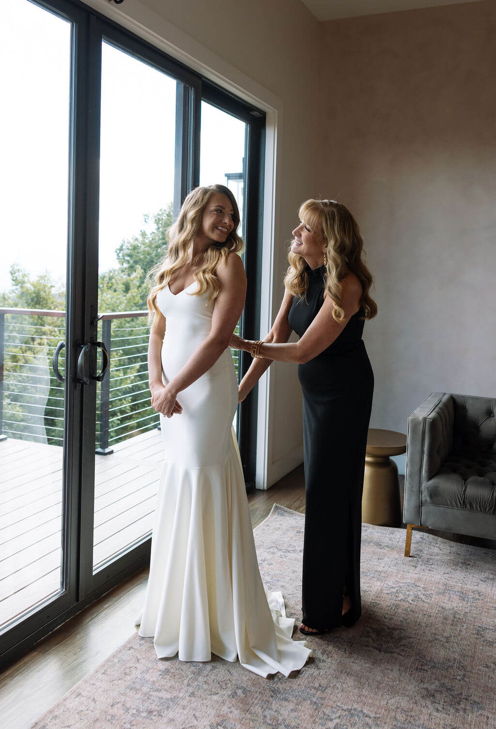 Bride getting ready with her mother before wedding ceremony