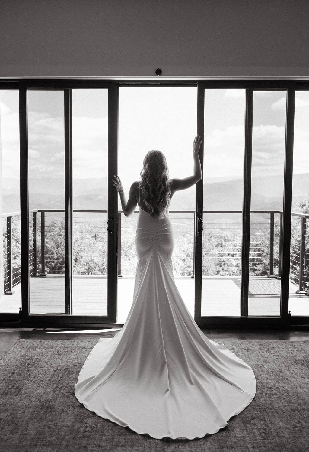 Black and white bridal portrait in front of floor to ceiling windows overlooking the mountains