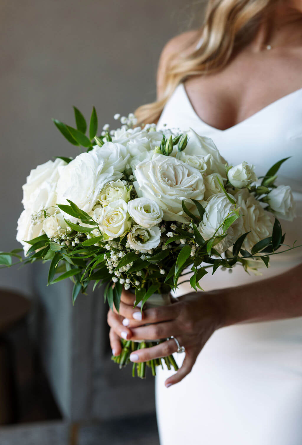 White bridal bouquet with roses and greenery detail photo