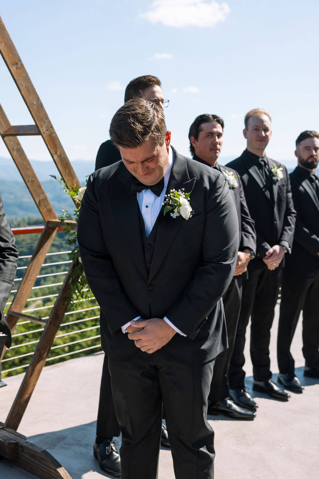 Groom reacting emotionally as bride walks down the aisle during mountain wedding ceremony