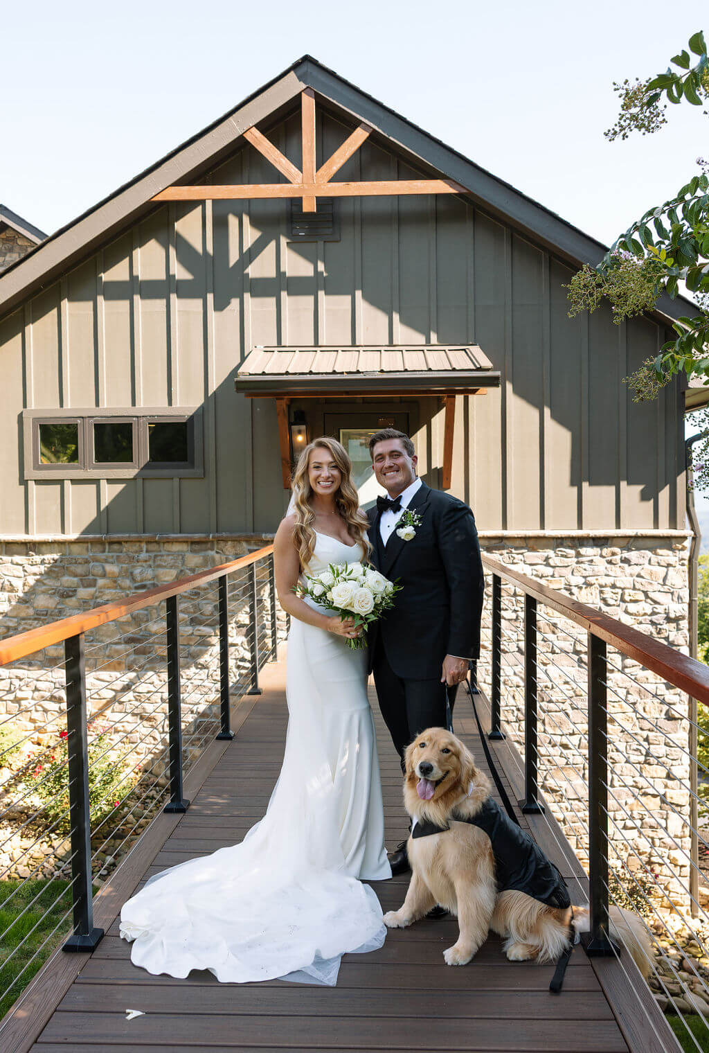 Bride and groom posing with their golden retriever outside a Knoxville wedding venue