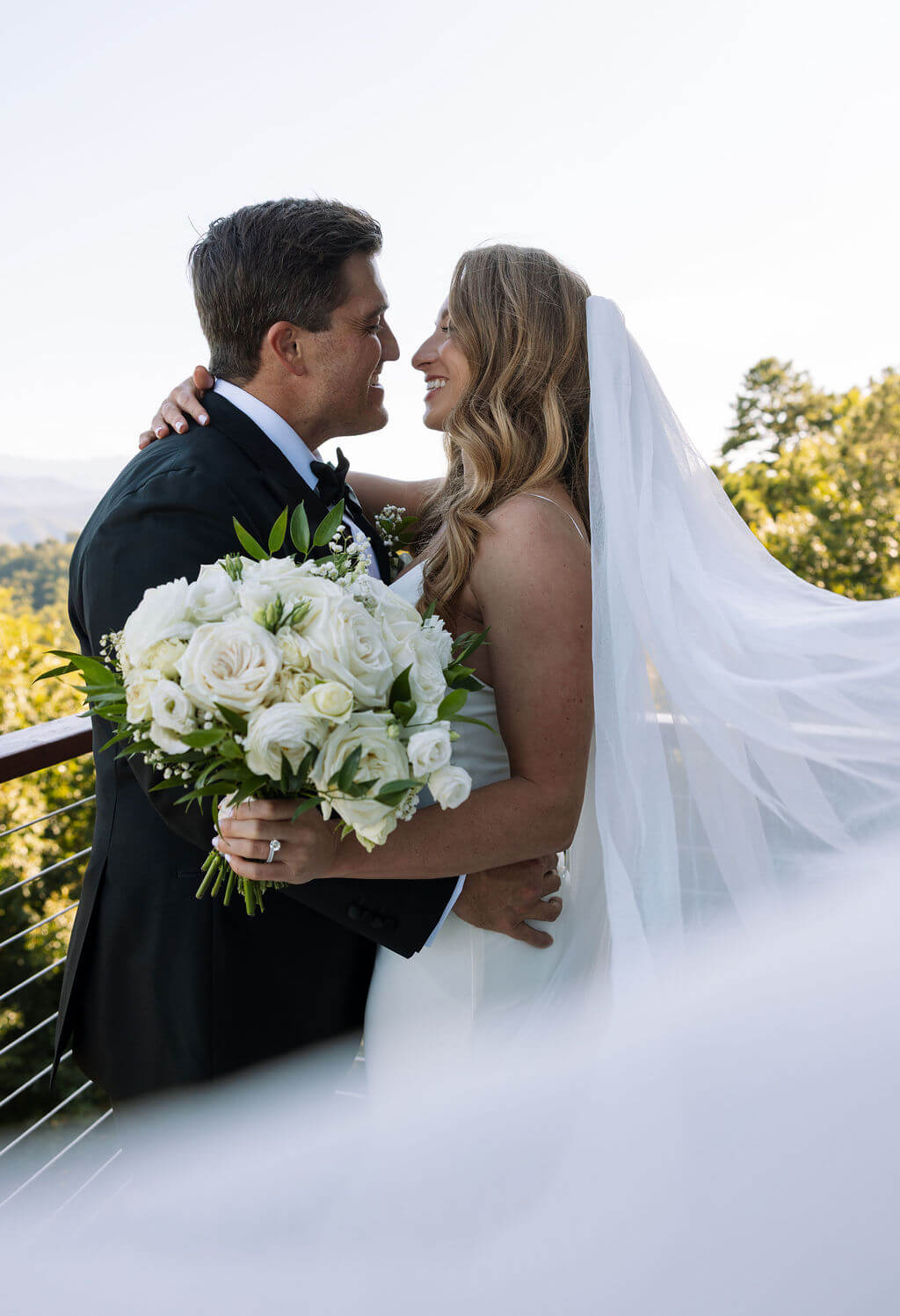 Bride and groom embracing on a mountain overlook at a Knoxville wedding venue
