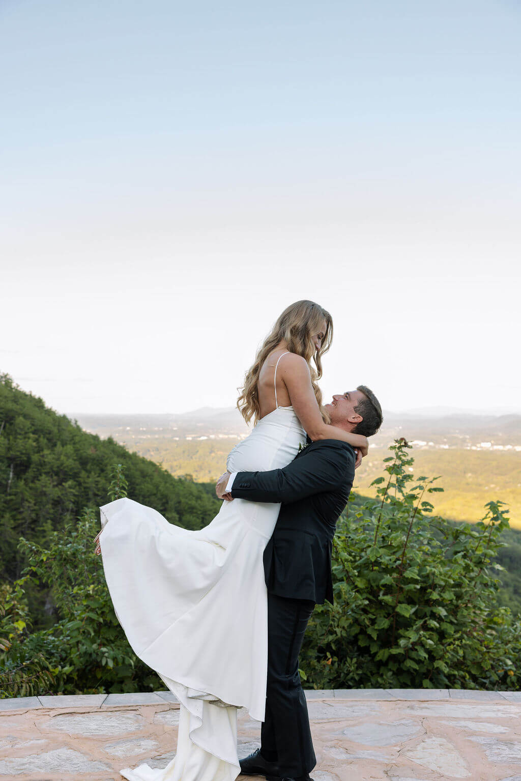 Groom lifting bride during sunset portraits at a Knoxville wedding venue