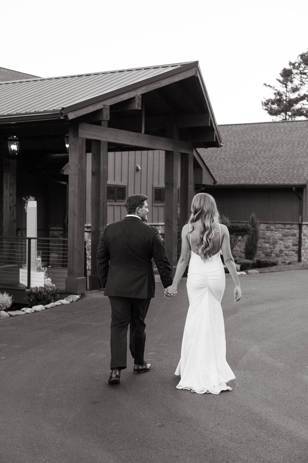 Black and white photo of newlyweds walking outside a Knoxville wedding venue