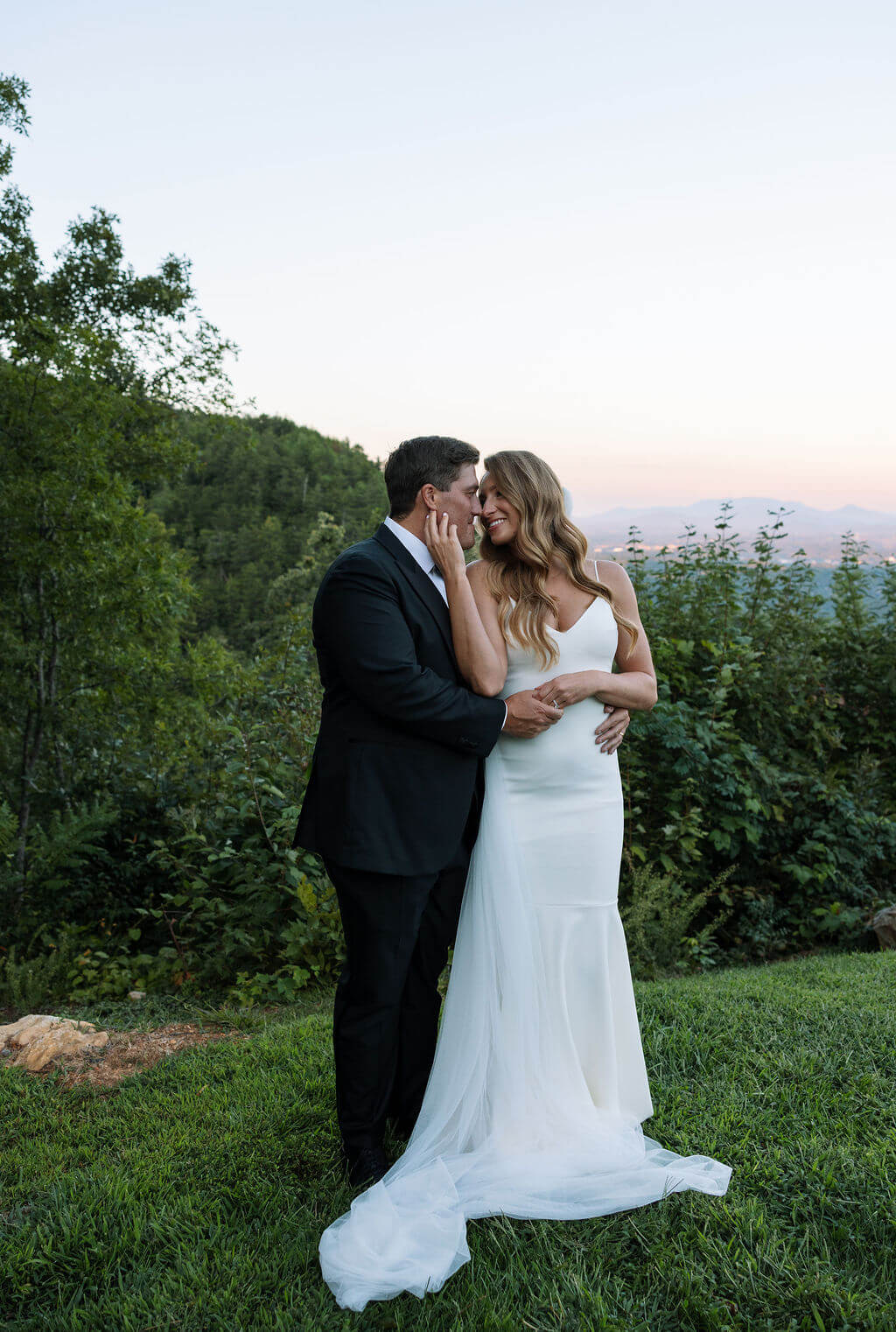 Newly married couple embracing outdoors with mountain views at a Knoxville wedding venue