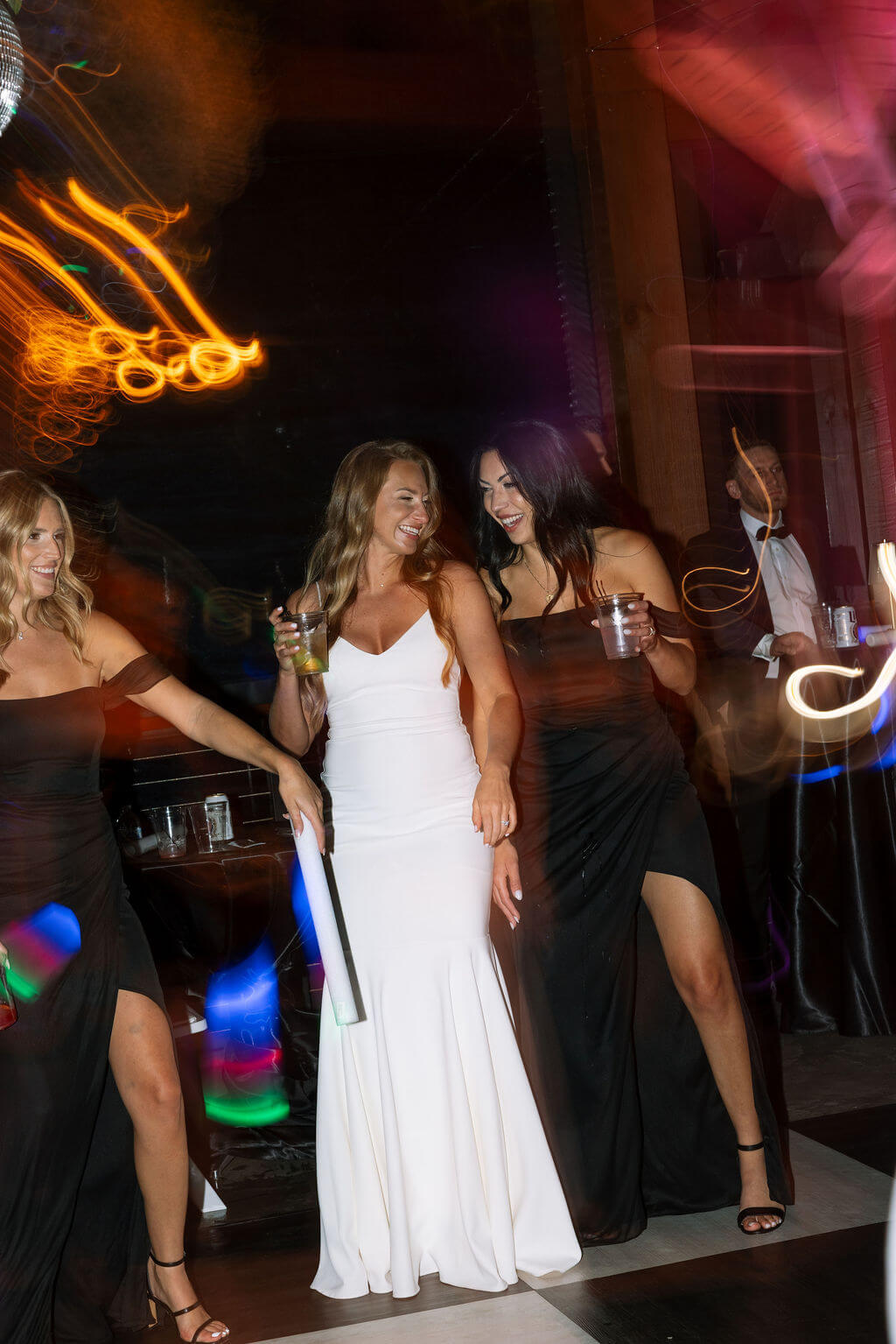 Bride dancing with bridesmaid during wedding reception party