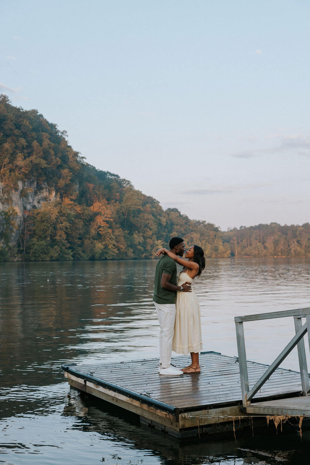Romantic proposal photos on a dock near Knoxville, Tennessee featuring the couple embracing after getting engaged.