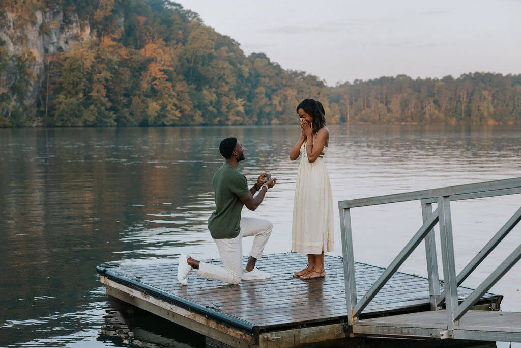 Proposal photo on a dock near Knoxville, Tennessee featuring a man proposing beside the lake during sunset.