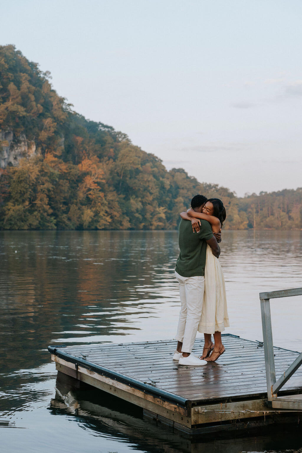 Couple hugging after a lakeside proposal near Knoxville, Tennessee during sunset.