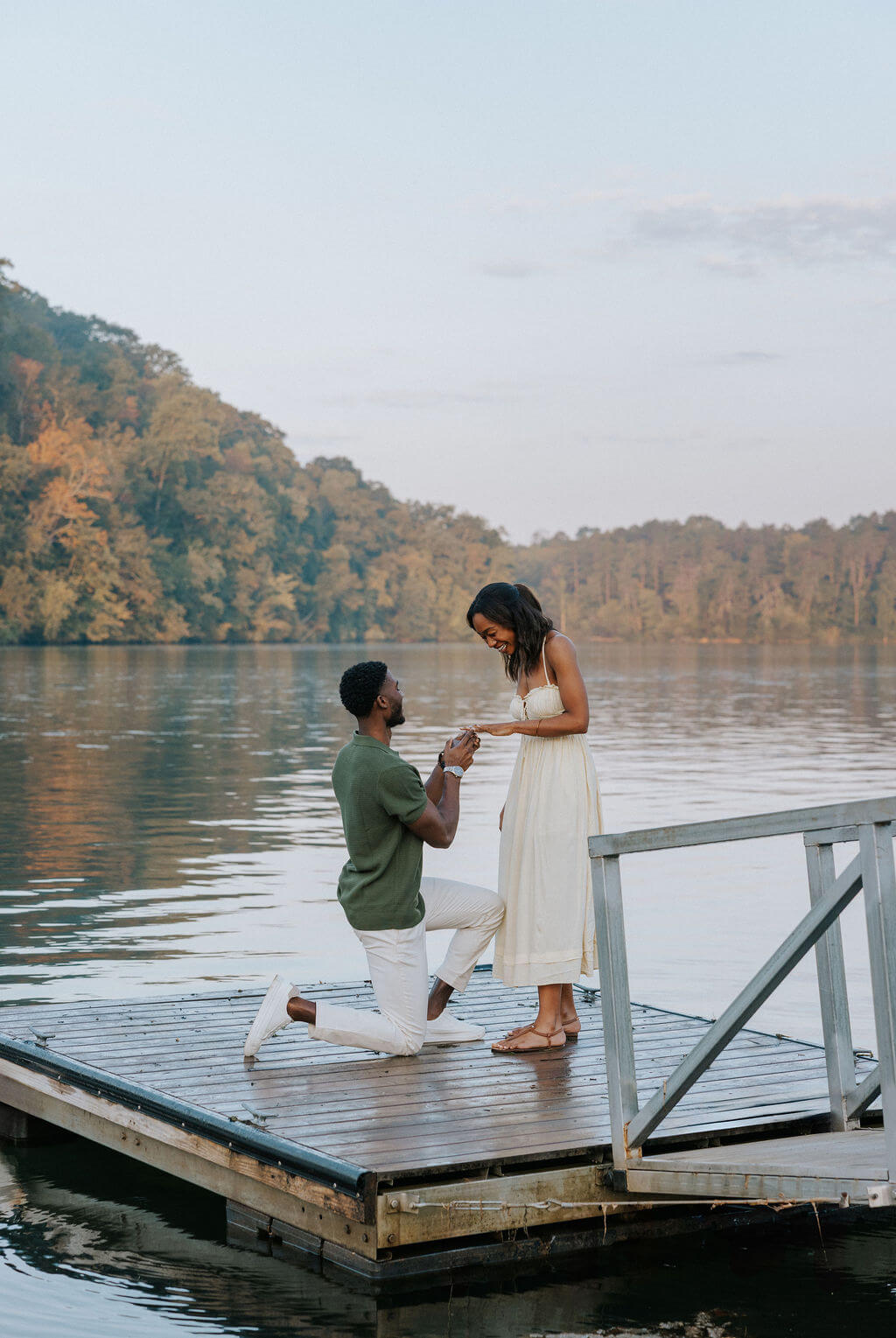 Proposal photo on a lakeside dock near Knoxville, Tennessee featuring the groom kneeling during sunset.