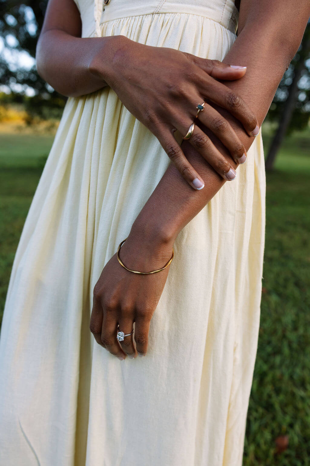 Close-up engagement ring photo during a Knoxville, Tennessee proposal session featuring neutral details and a cream dress.