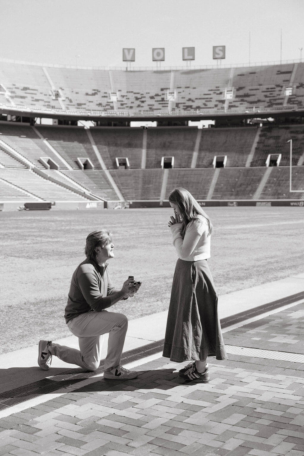 Black and white proposal photo at Neyland Stadium in Knoxville, Tennessee during the engagement moment on the football field.