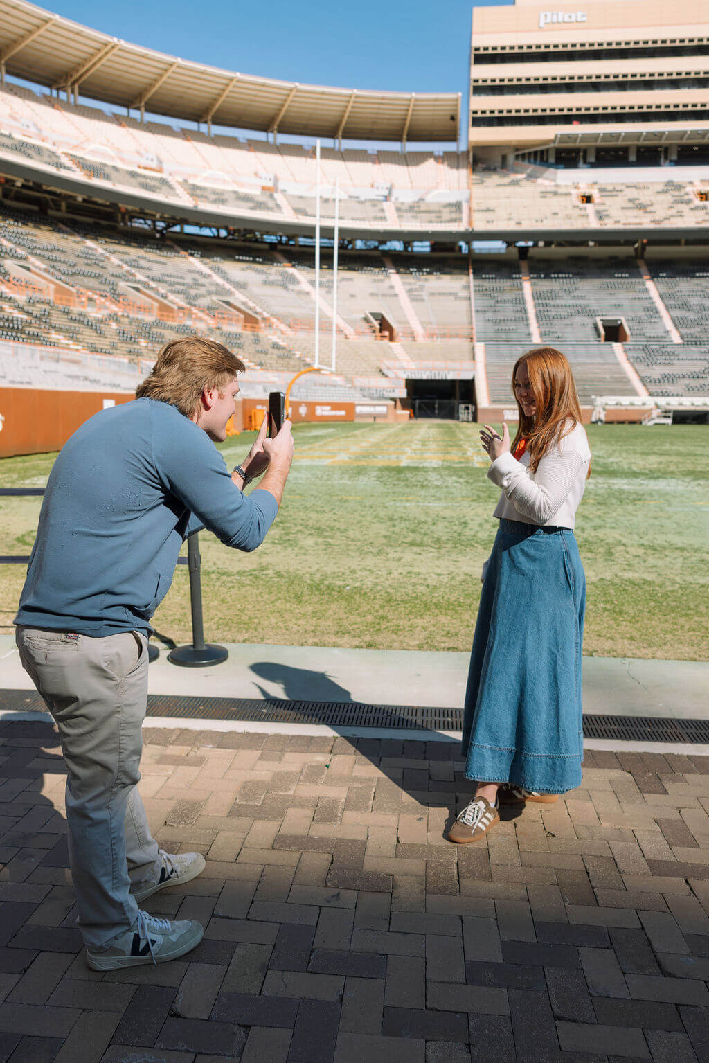 Proposal photo at Neyland Stadium in Knoxville, Tennessee featuring the groom kneeling with the engagement ring on the field.
