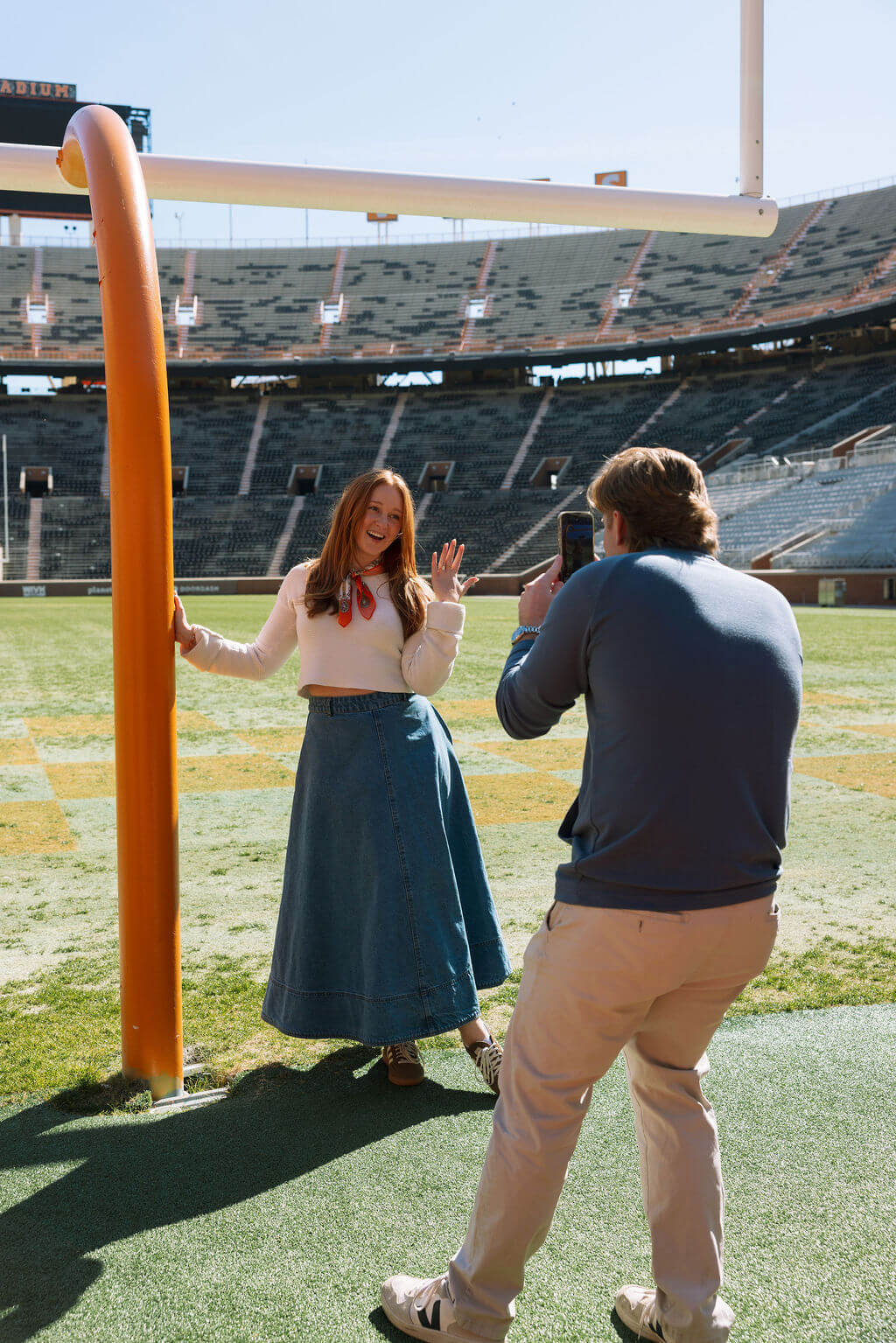 Candid proposal reaction at Neyland Stadium in Knoxville, Tennessee during an engagement session on the football field.