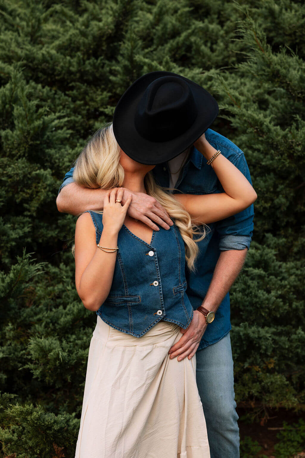 Playful engagement photo of a couple embracing in a field during a Knoxville, Tennessee couples session.