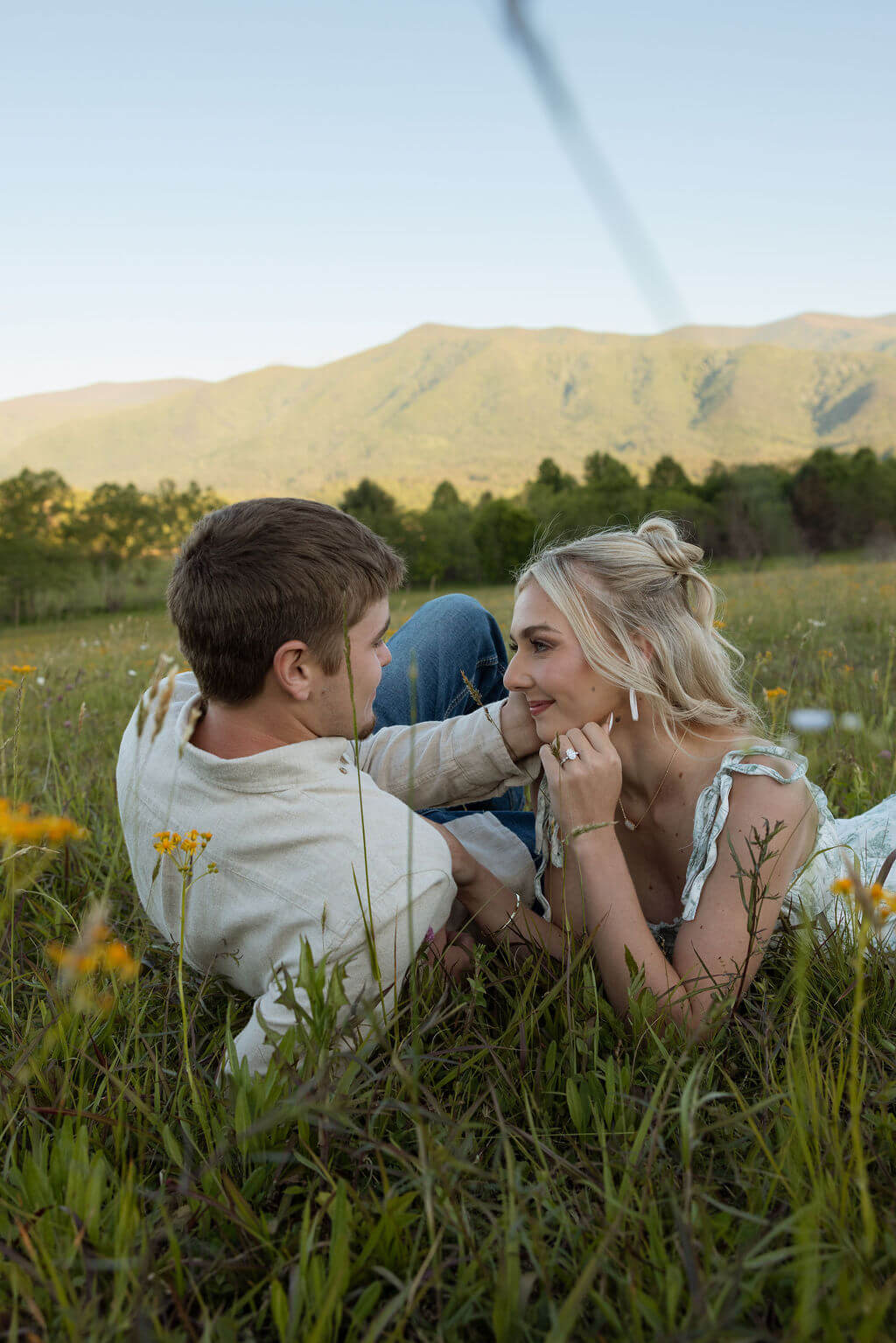 Couple lying together in the grass during a Knoxville, Tennessee engagement session at sunset.