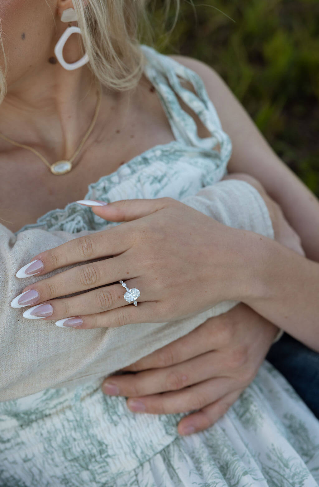 Close-up engagement ring photo during a Knoxville, Tennessee couples session featuring a floral dress and neutral details.