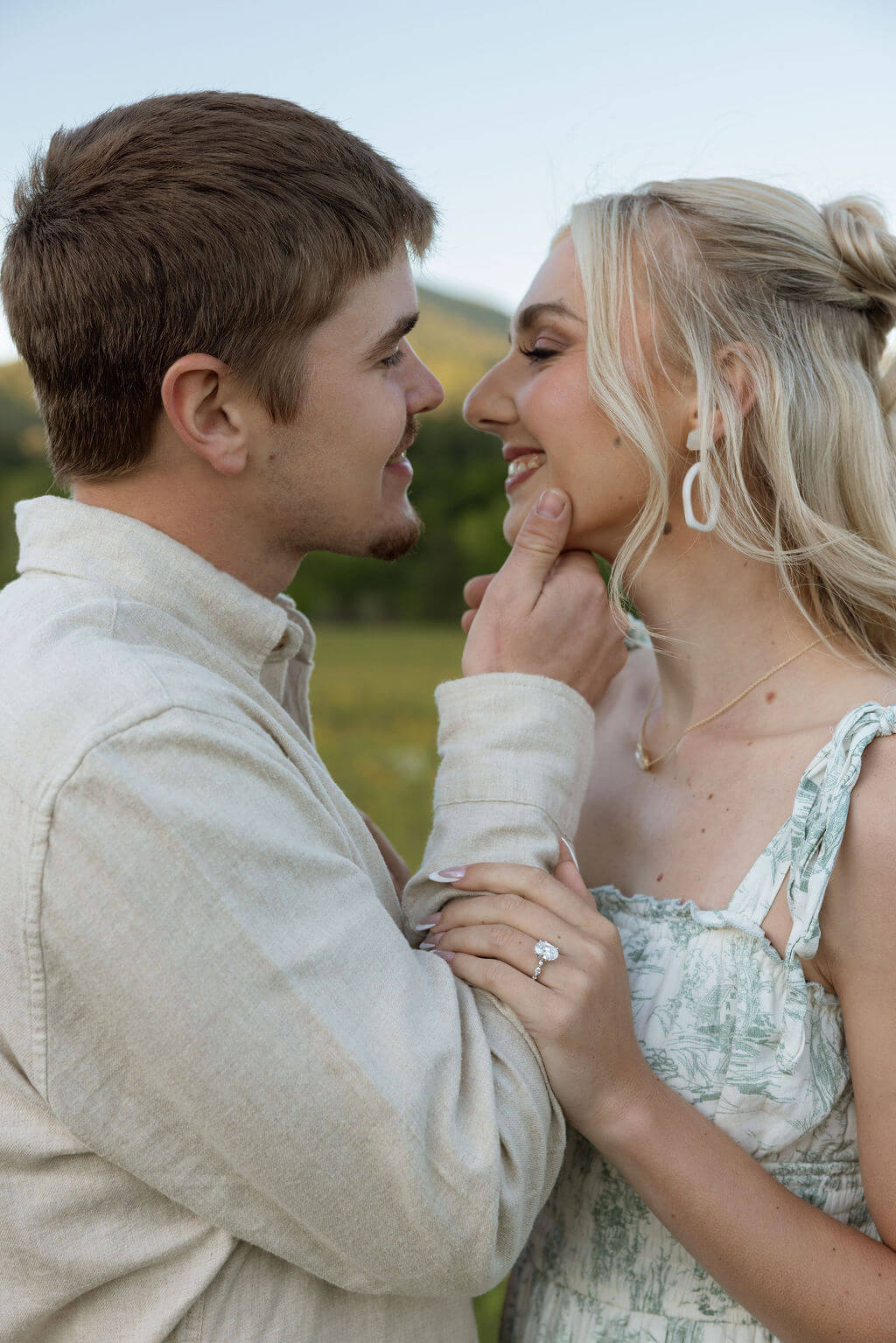 Close-up engagement portrait in a wildflower field near Knoxville, Tennessee featuring the couple smiling together.