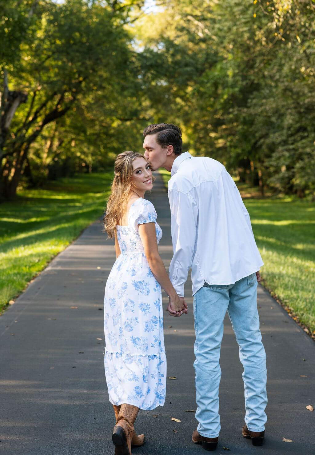 Golden hour engagement photos at Maple Grove Estate with couple walking on a paved road