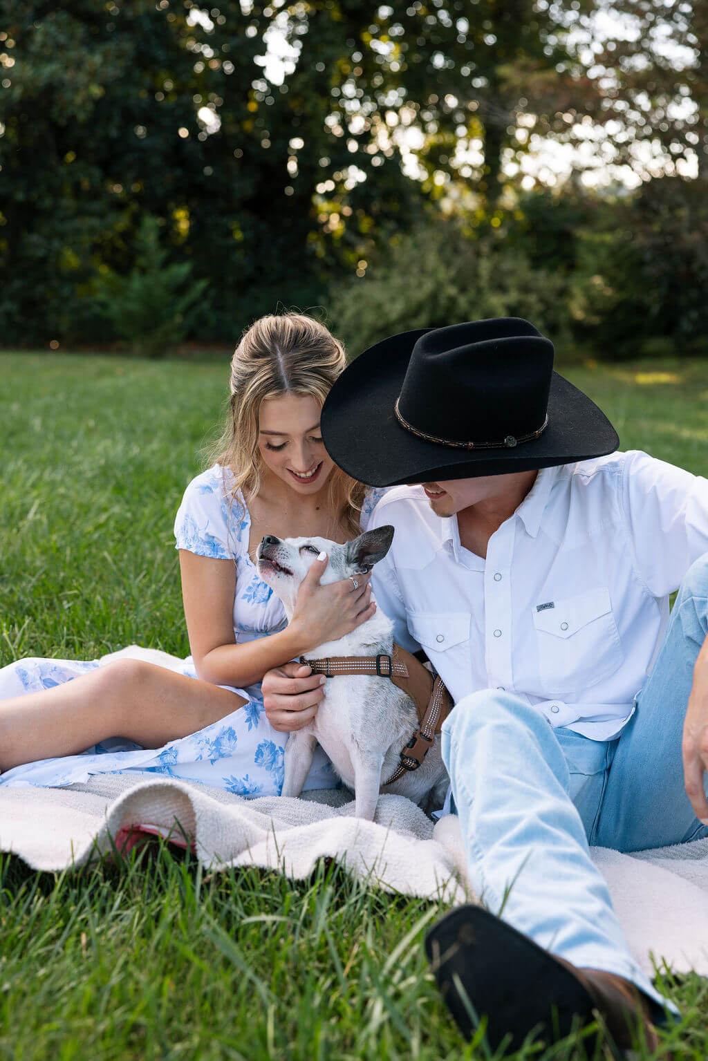 Couple cuddling with their dog during a relaxed Maple Grove Estate engagement photoshoot