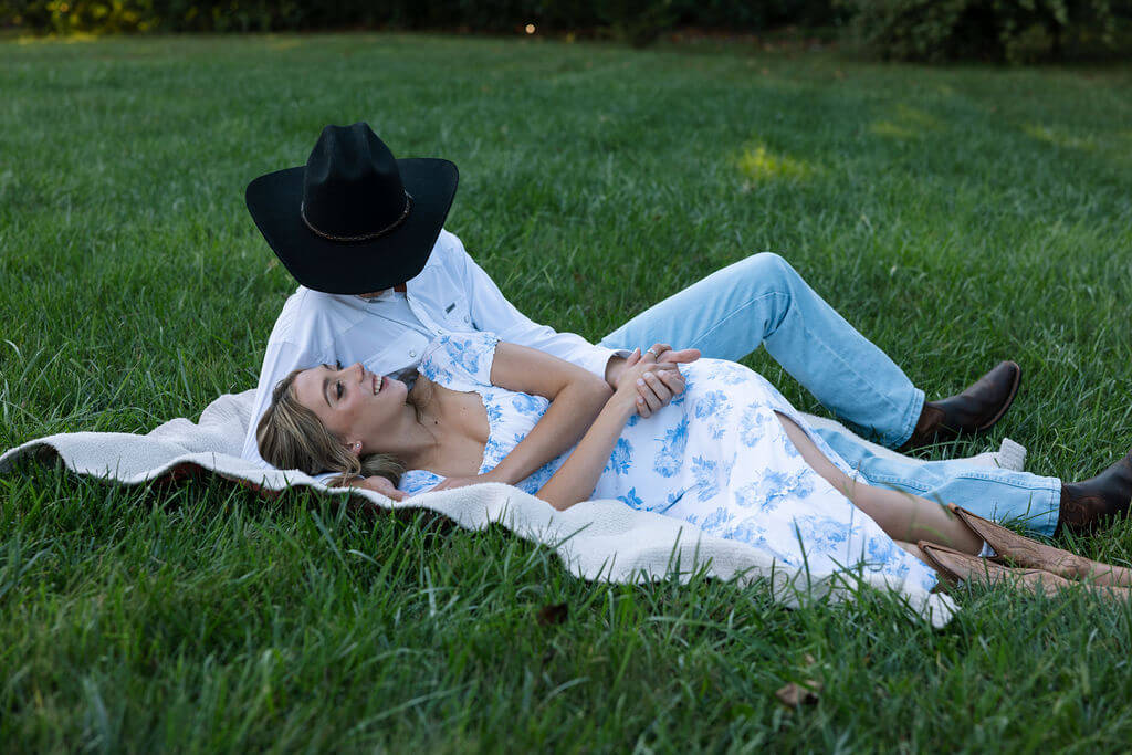 Couple lying together on a blanket during a relaxed engagement photoshoot at Maple Grove Estate