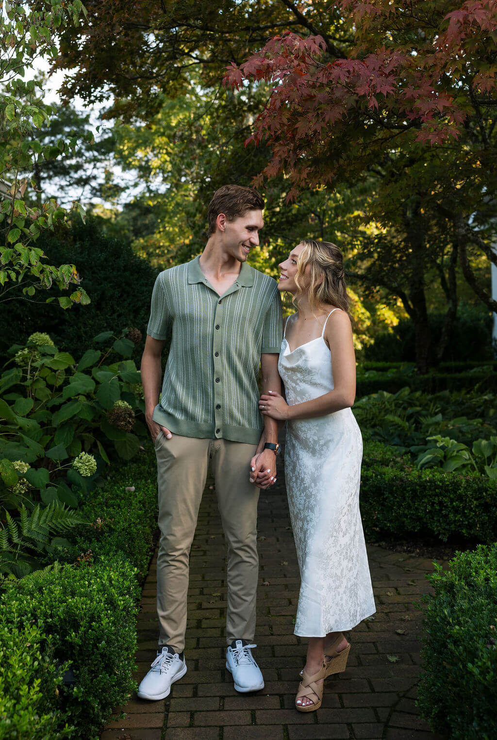 Romantic engagement photos in the gardens at Maple Grove Estate during golden hour