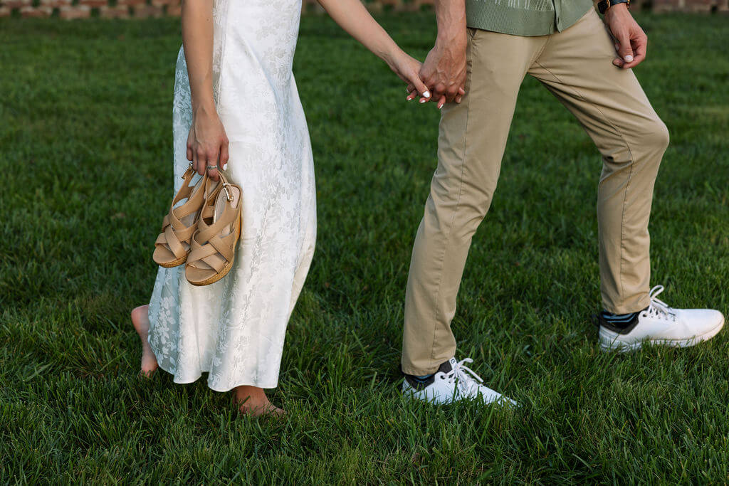 Detail engagement photo of couple holding hands and shoes during a Maple Grove Estate session