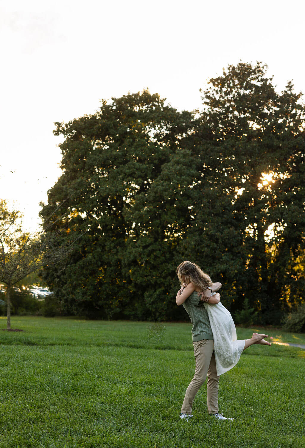Wide angle engagement portraits at Maple Grove Estate with open fields and sunset light
