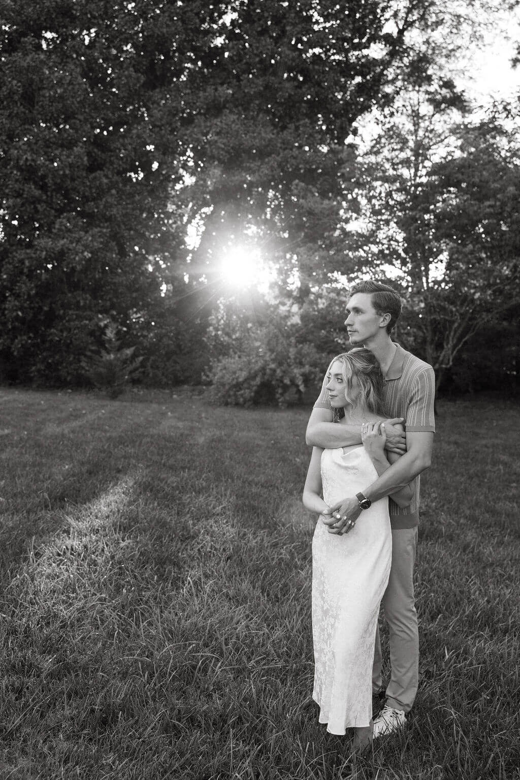 Black and white engagement portraits with sunset light filtering through the trees at Maple Grove Estate