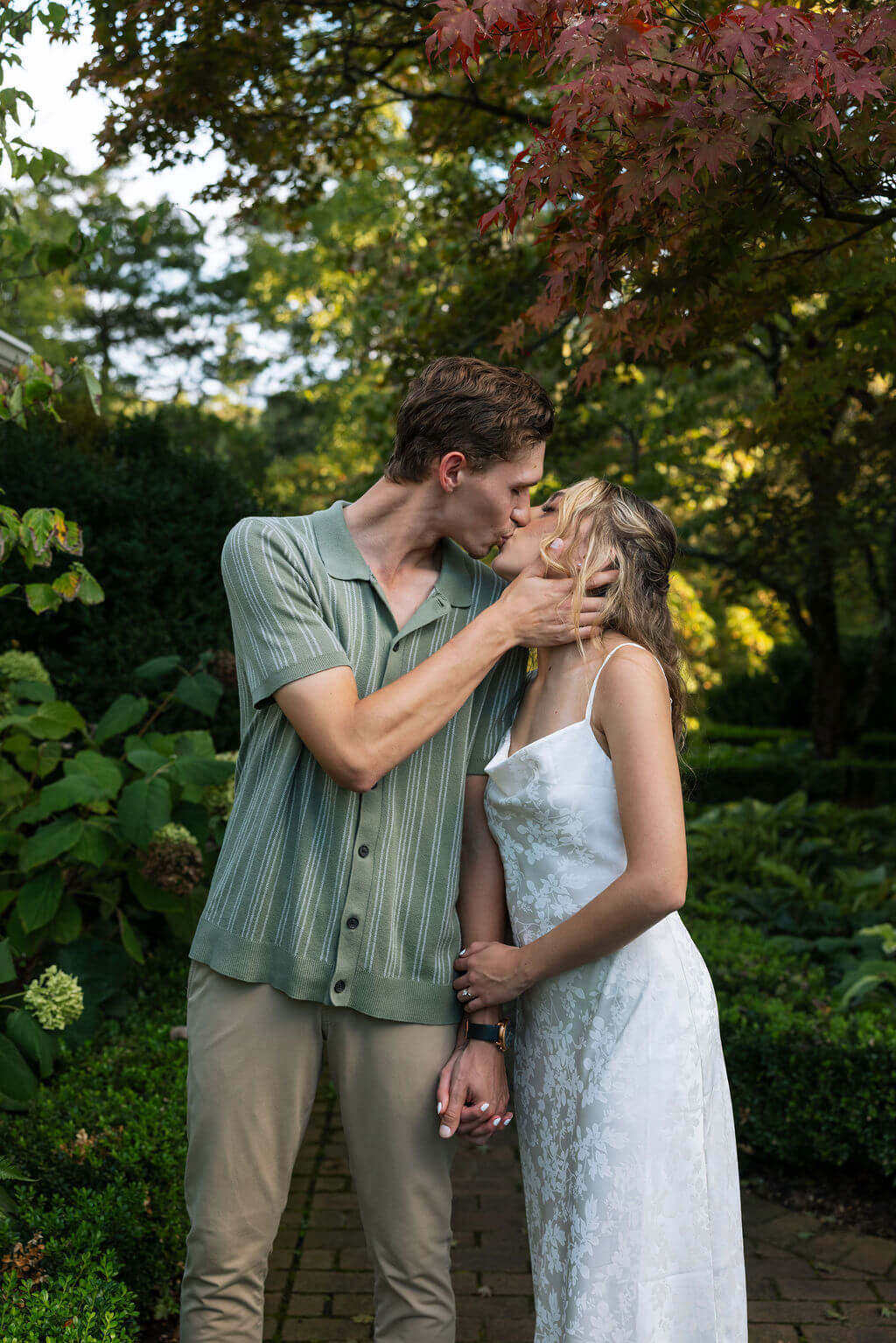 Romantic engagement portraits at Maple Grove Estate with lush greenery and gardens