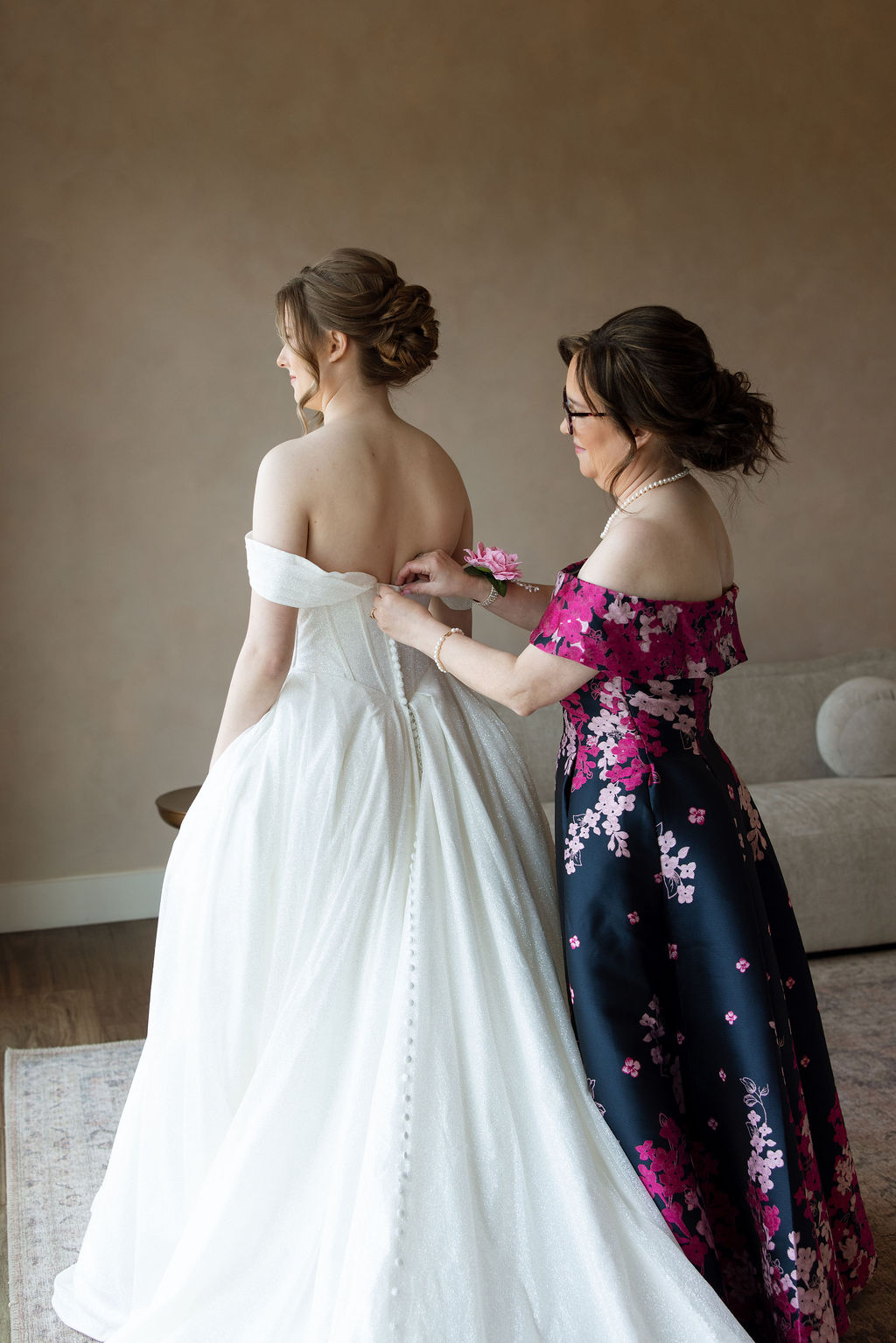 Mother of the bride helping button the wedding dress before the ceremony at a Sevierville wedding venue