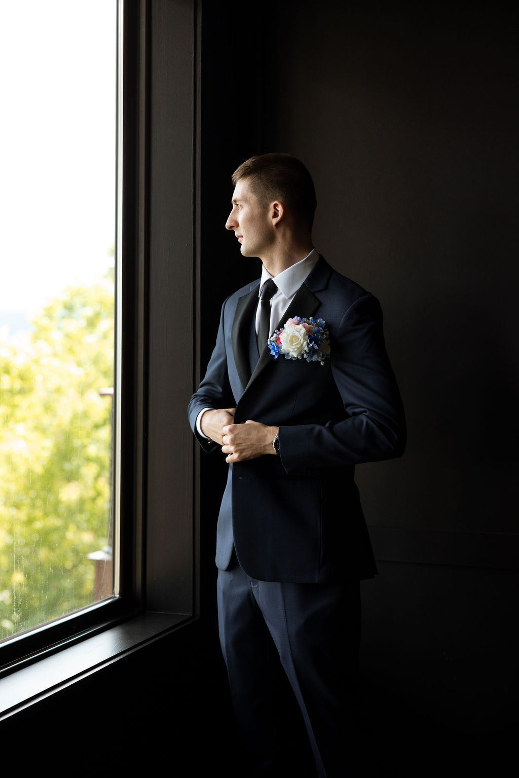 Groom portrait by the window while getting ready at a mountain wedding venue in Tennessee