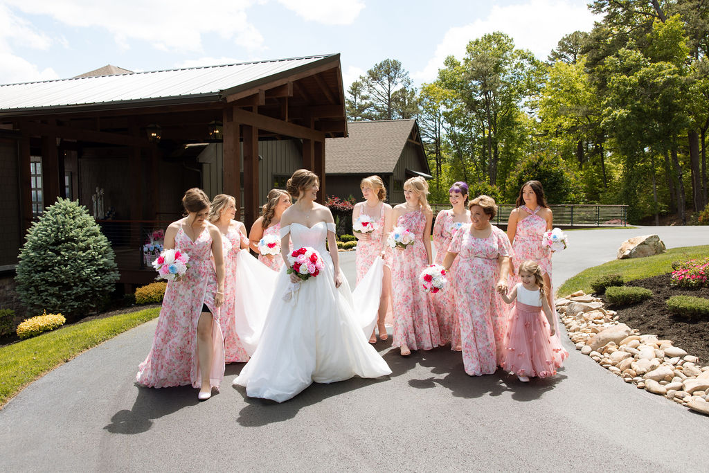 Bride walking with bridesmaids and flower girl outside a modern mountain wedding venue in Tennessee