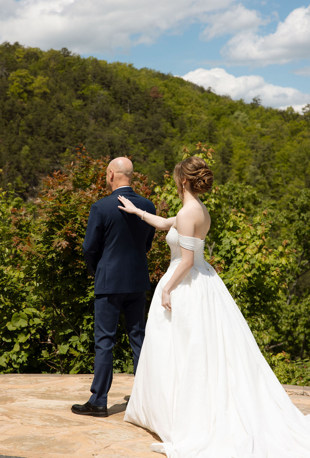 Bride tapping her father on the shoulder during an emotional first look before the ceremony