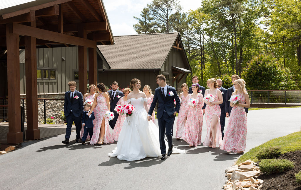 Bride and groom walking with their wedding party outside a Sevierville wedding venue on a sunny afternoon