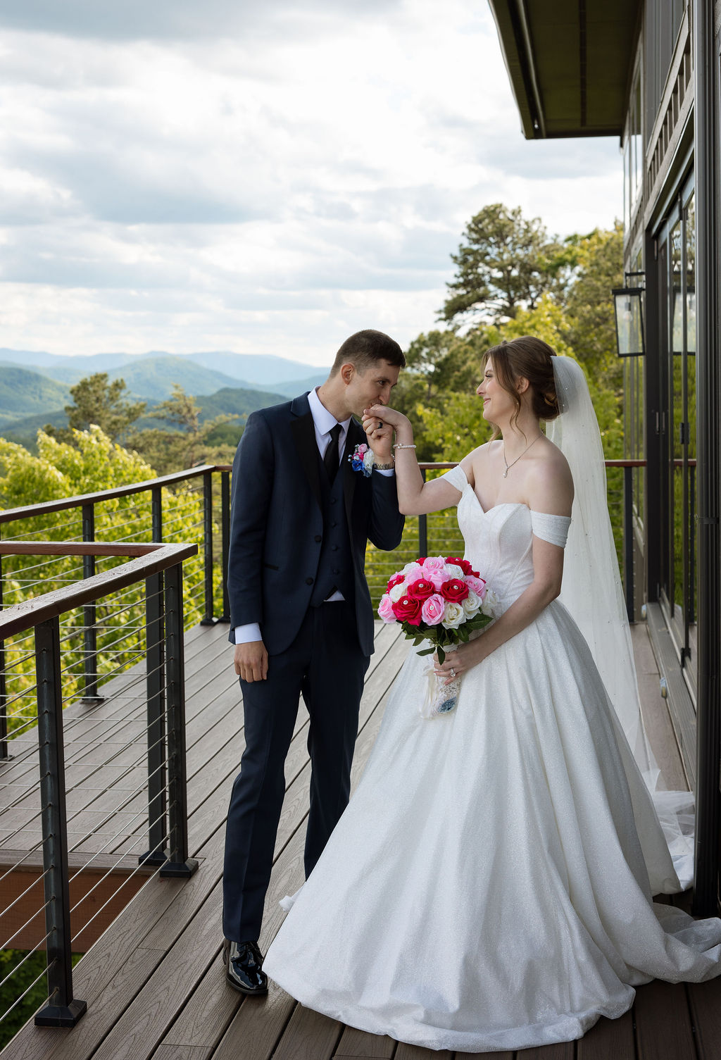 Bride and groom sharing a quiet moment on a balcony overlooking the Smoky Mountains at a Sevierville wedding venue
