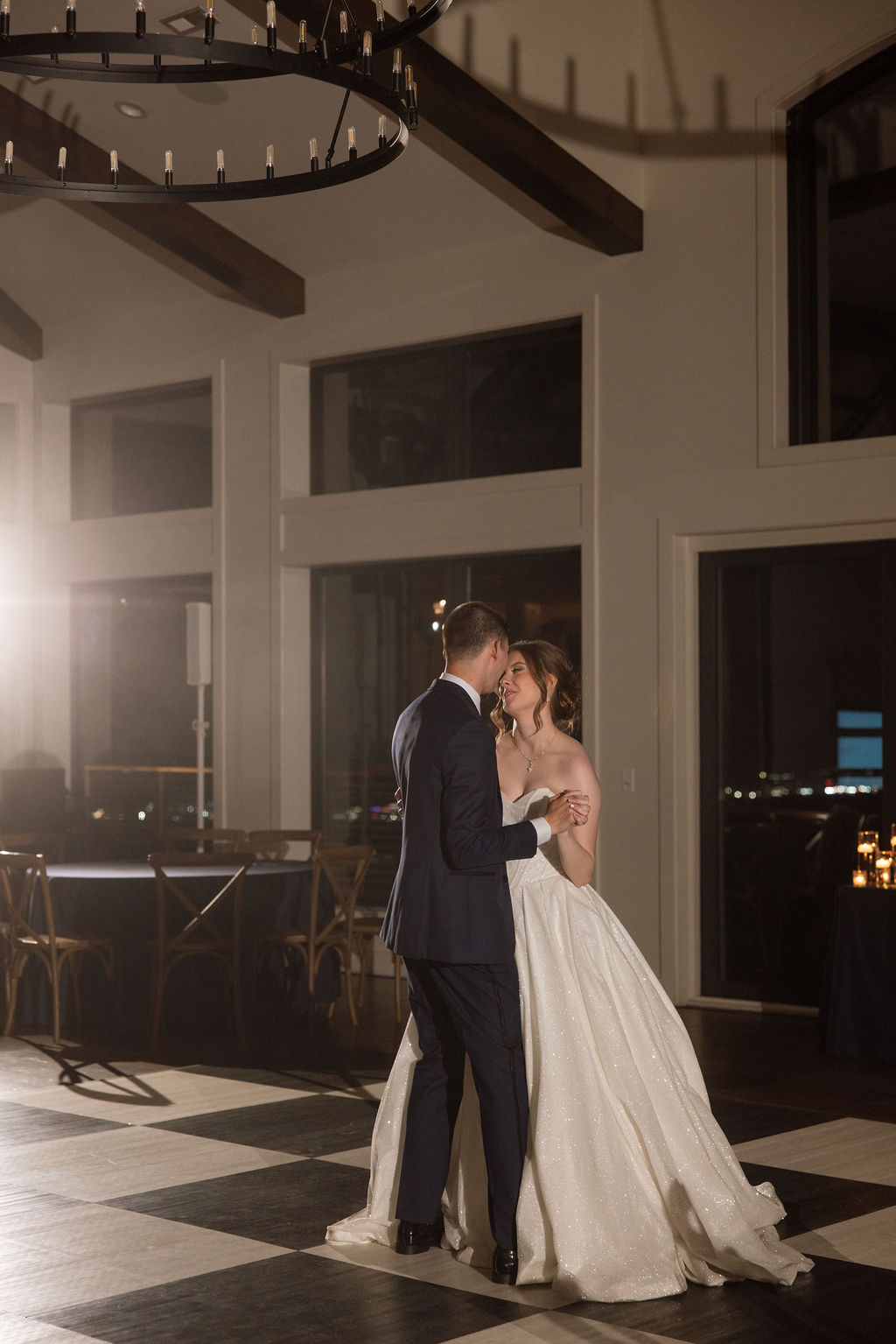 Bride and groom sharing a private dance inside a warmly lit reception space with mountain views