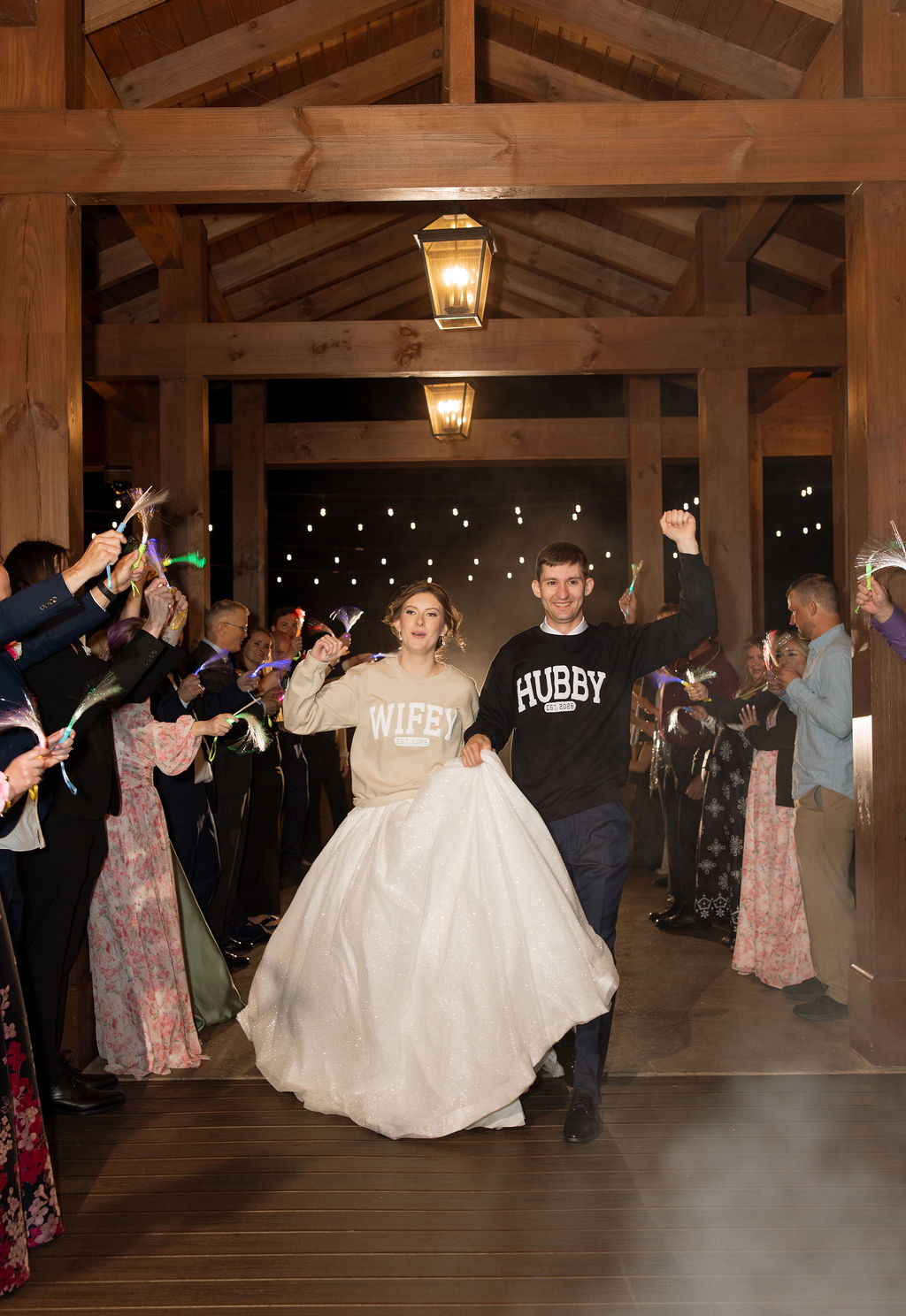 Bride and groom celebrating their reception exit in matching wifey and hubby sweatshirts at a Sevierville wedding venue