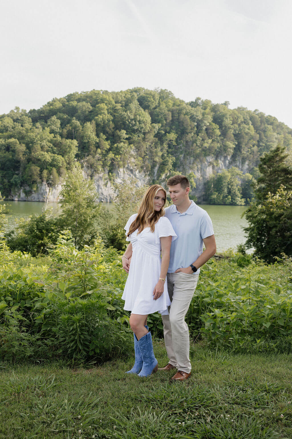 Engaged couple walking beside a lake during their Knoxville summer engagement session.