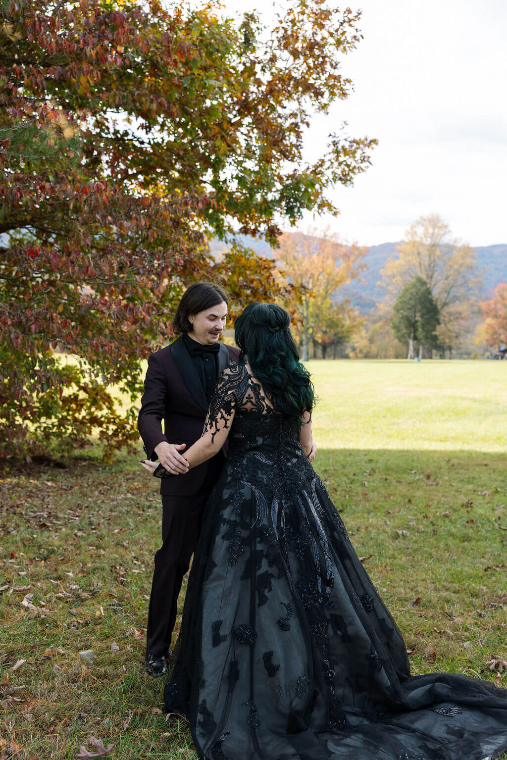 The couple embraces during their first look, surrounded by colorful fall trees at Cove Lake State Park.