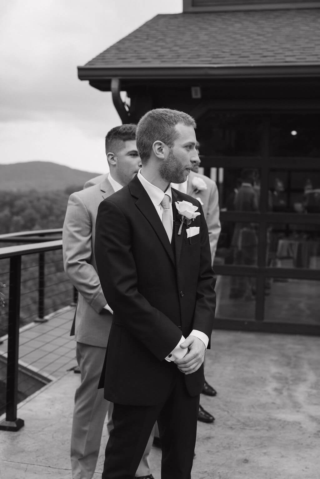 Black-and-white photo of the groom waiting at the outdoor ceremony space at The Magnolia.